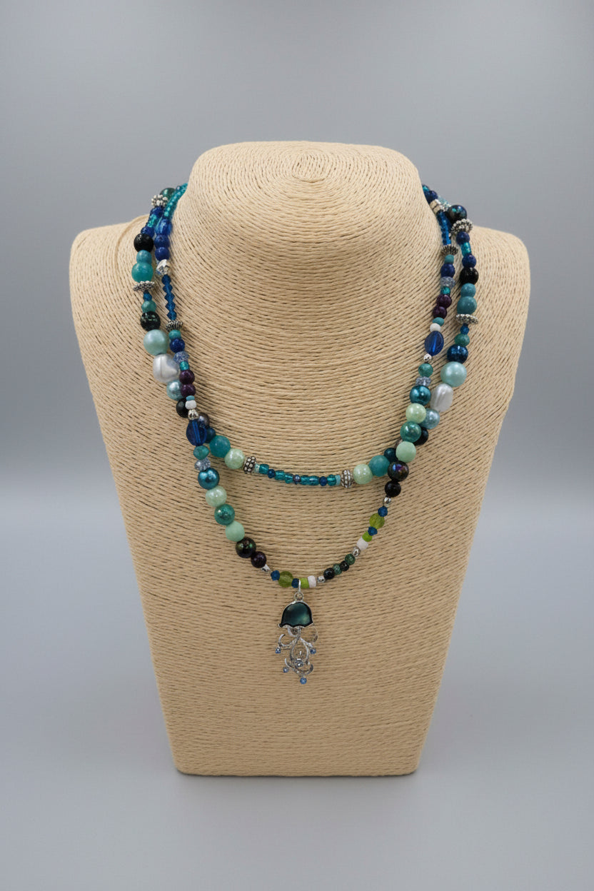 Beaded necklace on a beige bust against a gray background