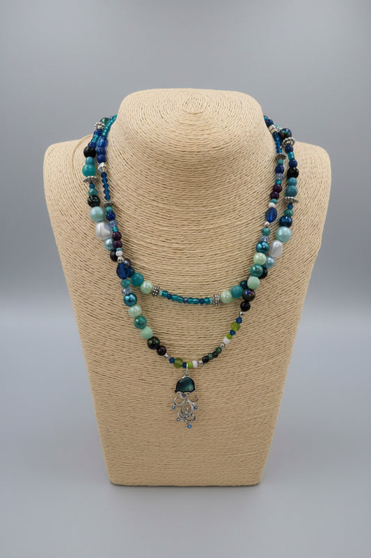 Beaded necklace on a beige bust against a gray background